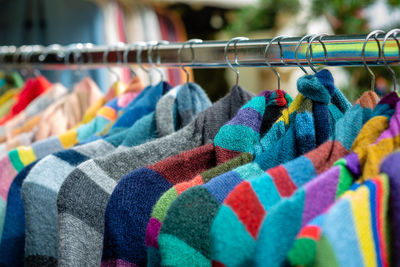 Close-up of multi colored clothes hanging in store for sale