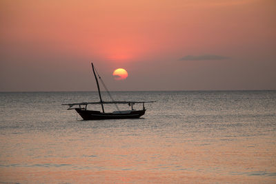 Silhouette boat in sea against sky during sunset