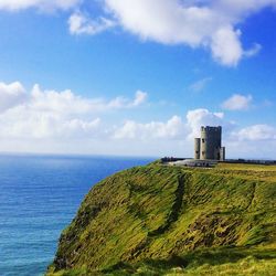 View of castle on cliffs of moher by sea against sky