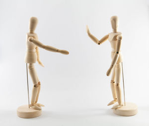 Close-up of figurine on table against white background