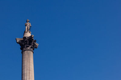 Low angle view of statue against blue sky