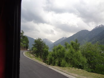 Road by mountains against sky