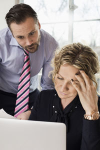 Senior businesspeople looking at laptop in office