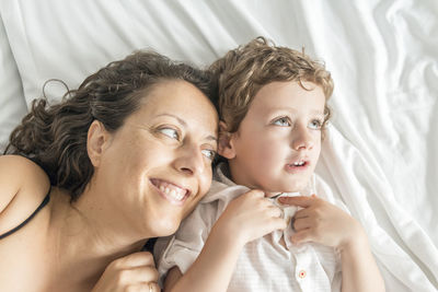 Portrait of happy mother and baby on bed