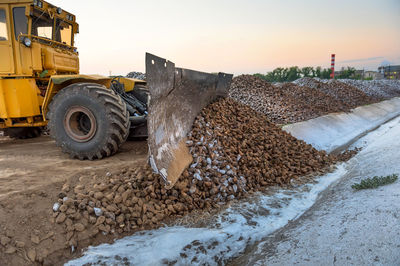 Earth mover at construction site against sky