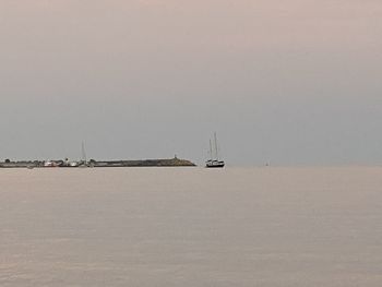 Sailboat sailing on sea against clear sky