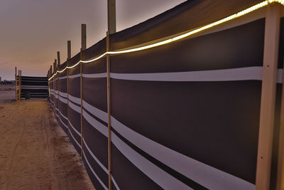 Train on railroad tracks against sky at sunset