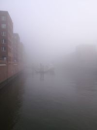 Scenic view of foggy weather against sky during winter