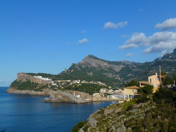 Scenic view of sea by buildings against sky porto soller, majorca