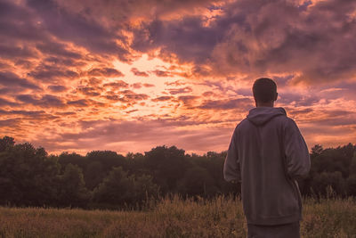 Silhouette of people on field at sunset