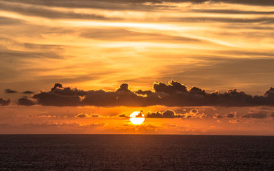 Scenic view of sea against orange sky