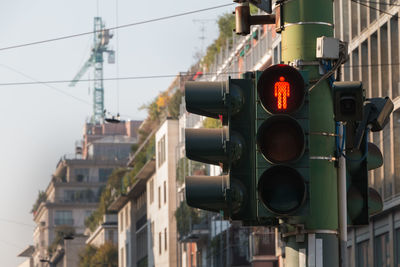 Traffic light prohibiting the passage of pedestrians in the street of a large italian city