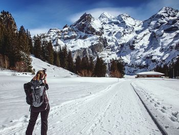 Man standing on snow covered mountain against sky