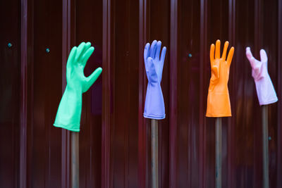 Multi colored washing up gloves against wall