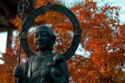 Close-up of statue against trees during autumn