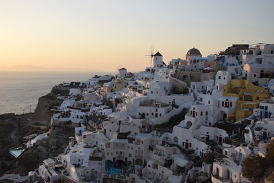 Aerial view of townscape by sea against sky