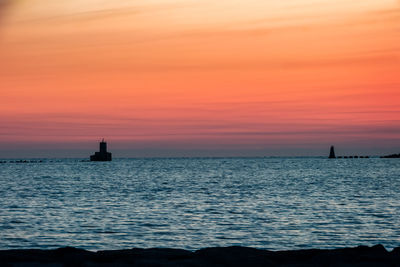 Scenic view of sea against orange sky, sunset over horizon