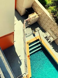 High angle view of swimming pool by building on sunny day