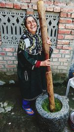 Portrait of smiling girl standing against tree