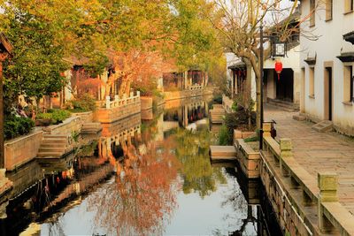 Canal amidst buildings in city during autumn