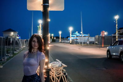 Full length of woman standing on road at night