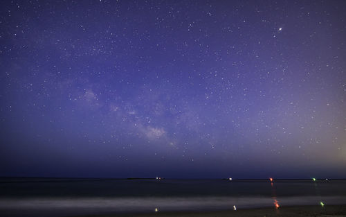 Scenic view of sea against star field at night