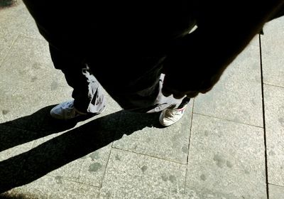 Low section of woman standing on footpath