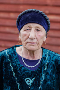 Portrait of senior woman against red wall