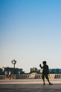 Full length of woman standing against clear sky