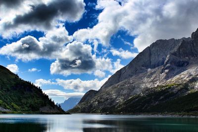 Scenic view of lake against mountains and cloudy sky