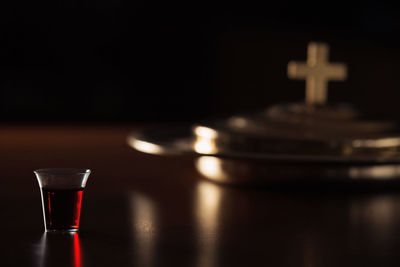 Close-up of wineglass on table against black background