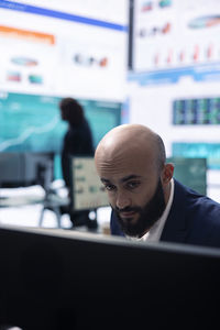 Close-up of man using laptop at cafe