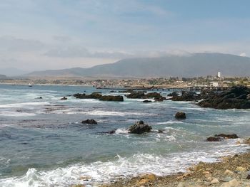 Scenic view of sea and mountains against sky