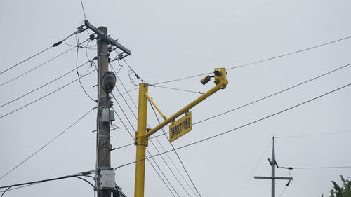 Low angle view of electricity pylon against clear sky