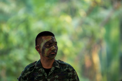Portrait of young man looking away outdoors