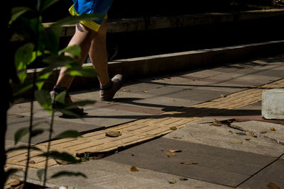 Low section of man walking on footpath