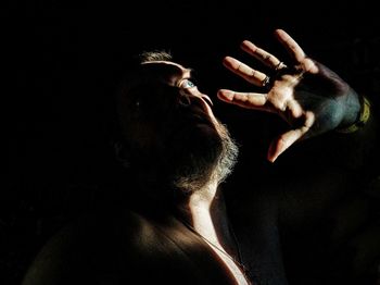 Scared shirtless man in darkroom