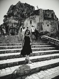 Woman standing on staircase of building