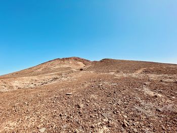 Scenic view of arid landscape against clear blue sky in lanzarote