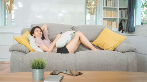 Woman sitting on sofa at home