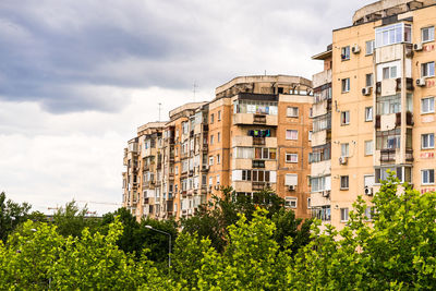 Low angle view of buildings against cloudy sky