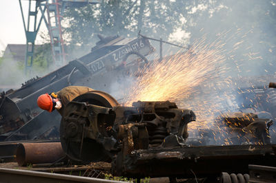 Welder welding scrap metal of train