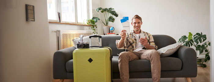 Rear view of woman sitting on sofa at home