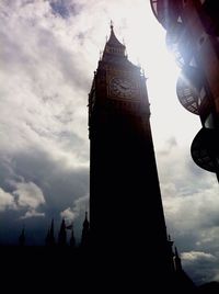 Low angle view of clock tower against cloudy sky