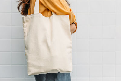 Rear view of woman standing against white wall