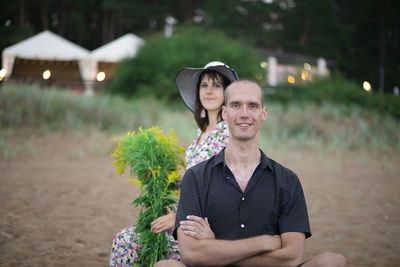 Young romantic couple-man and woman posing on the beach on a rainy summer day,looking to camera