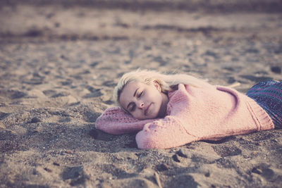 Portrait of boy lying on sand at beach