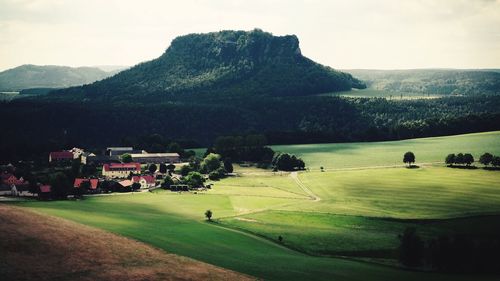 People on golf course against sky