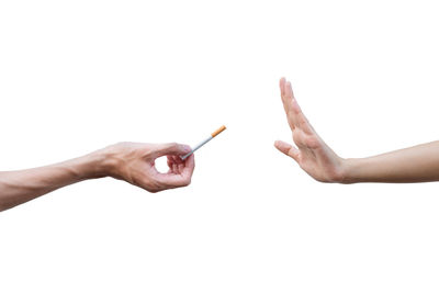 Close-up of hand holding hands over white background