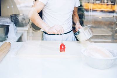 Midsection of man preparing food in kitchen